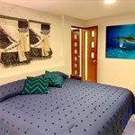 A bed with pillows and a painting on the wall