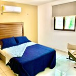 A bed with blue sheets and a wood headboard in a room